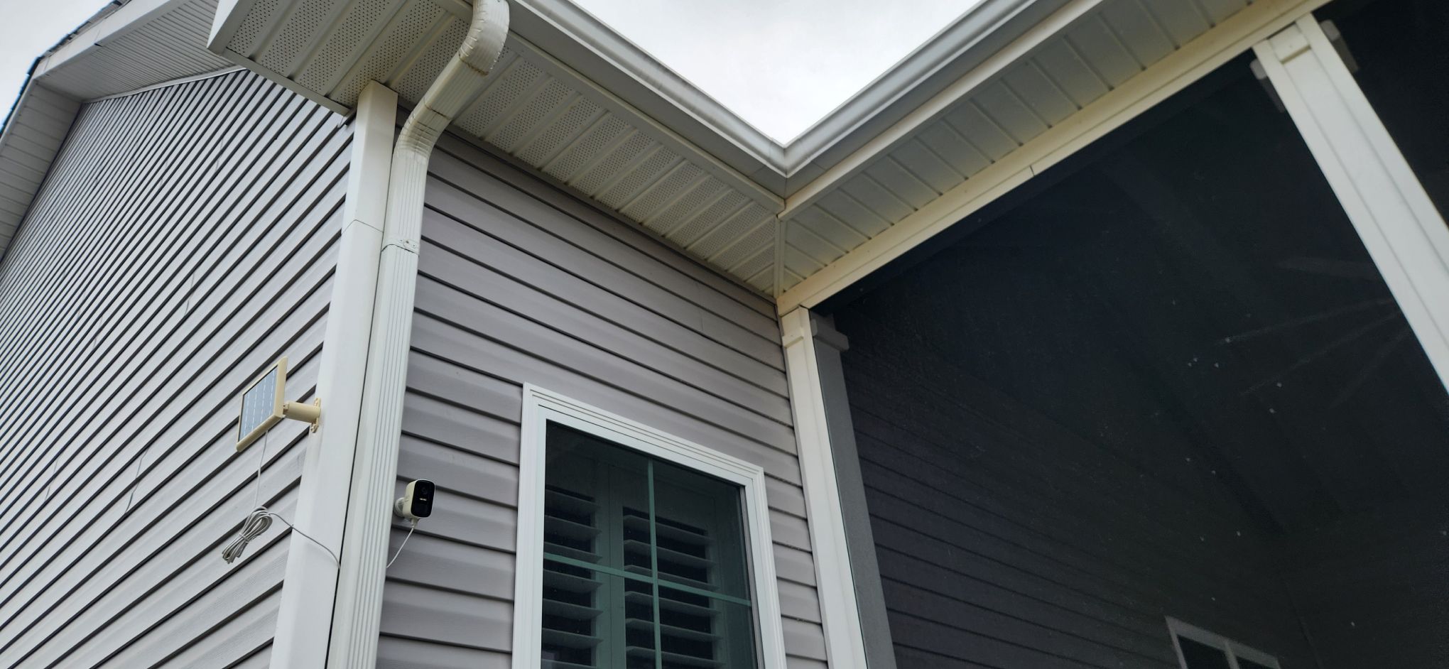 Covered porch entryway with gray siding, white trim, and glass door in Omar DE
